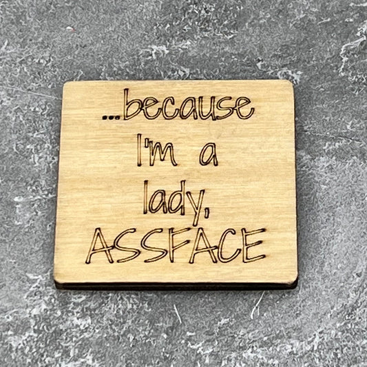 2" wood square with “Because I’m a lady, ASSFACE“ laser engraved