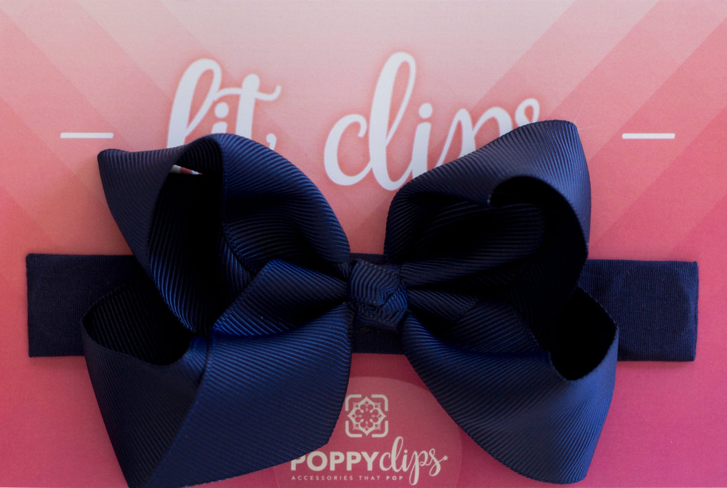 5 ¼” long by 7/8” wide navy blue material with hidden magnets at each end. Centered on the outside is a double navy blue bow that is approximately 4” across.