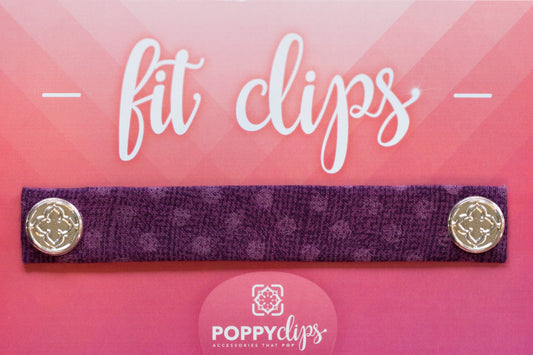 5 ¼” long by 7/8” wide purple material with lighter purple dots, and magnets at each end.  The outer magnets are a decorative silver medallion with the company logo.