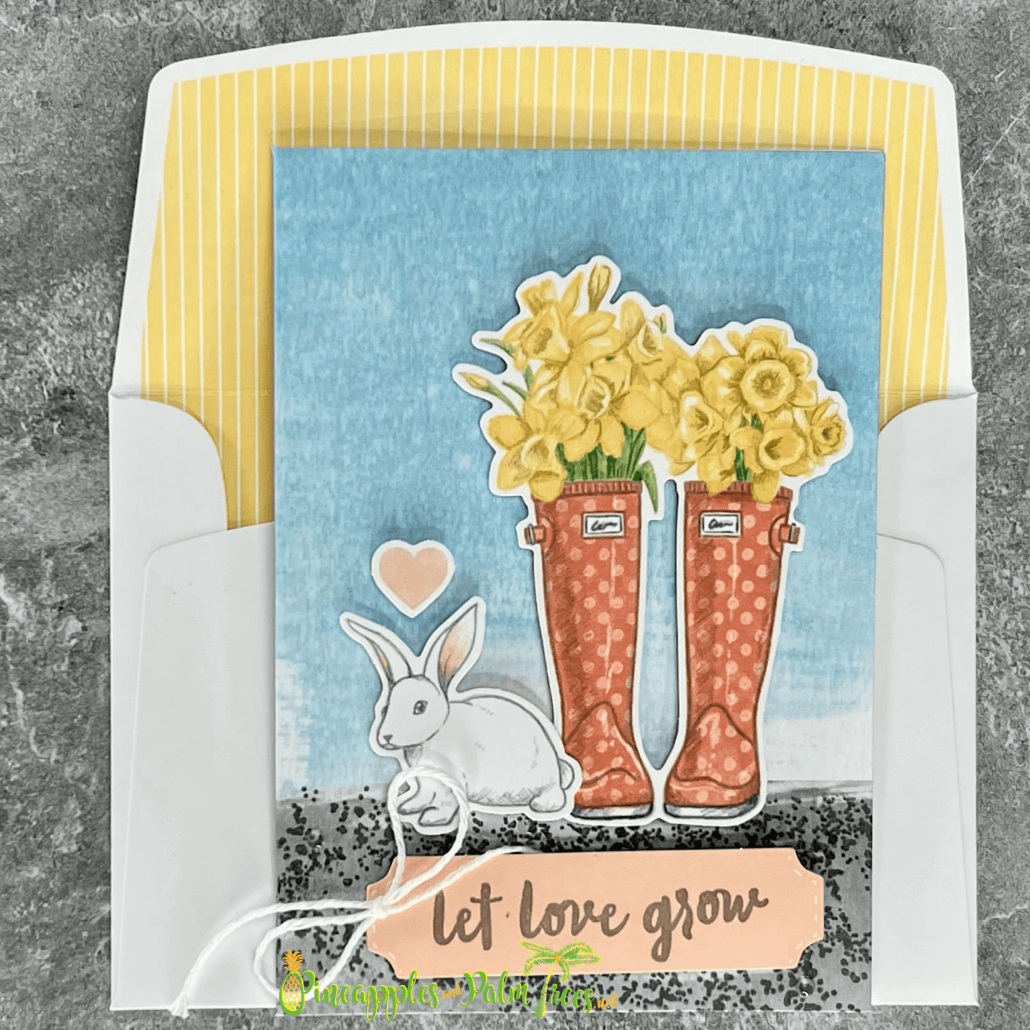 Greeting card with the message ‘Let Love Grow’ featuring a pastel bunny and floral illustration, shown with its matching envelope — sweet and handcrafted.