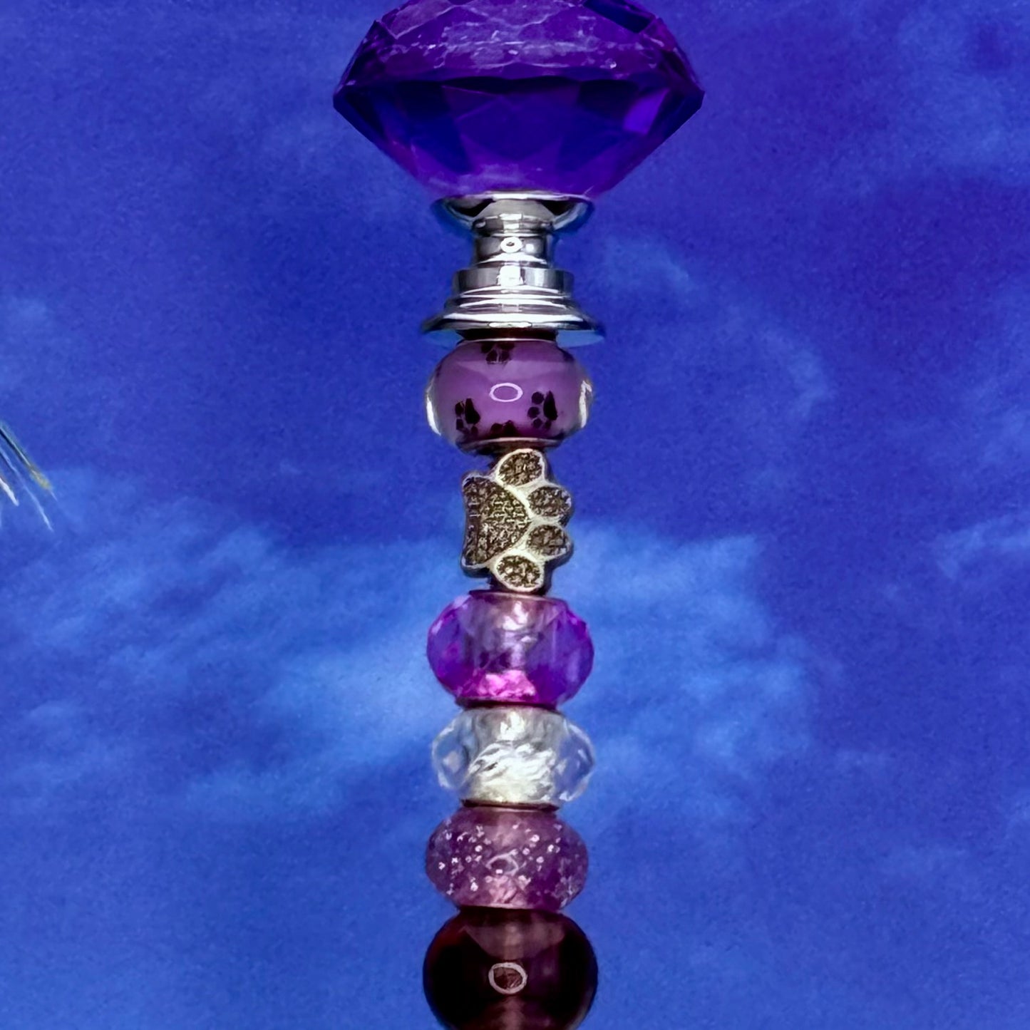 Purple metal garden stake with paw print and petal design — cute pet and floral-themed outdoor décor.