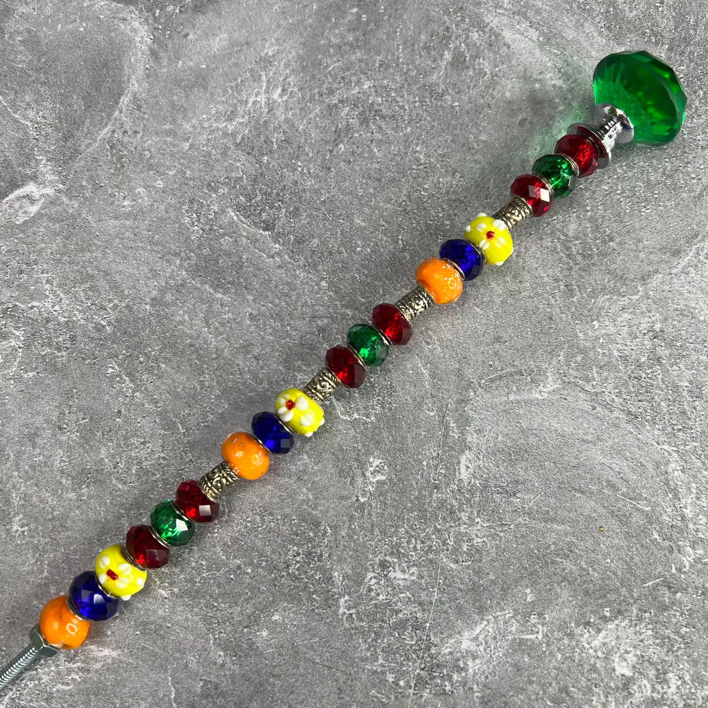 Metal garden stake with a colorful rainbow palette design — decorative outdoor yard décor.