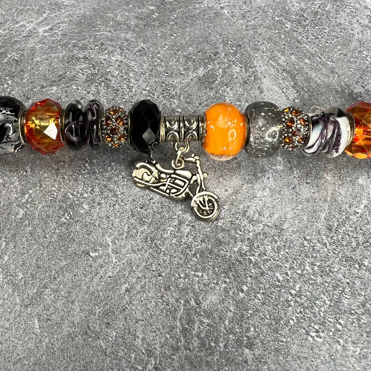 Black and orange metal garden stake shaped like a motorcycle — ‘Sunset Chopper Charm’ yard décor for bike lovers.