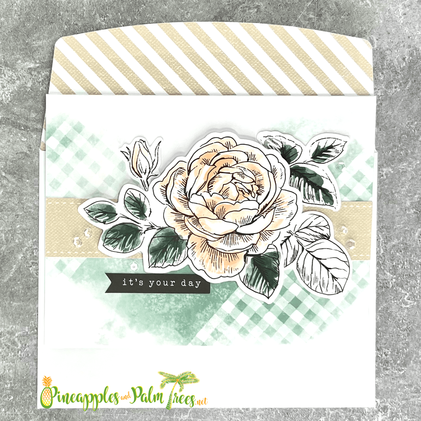 Greeting card with ‘It’s Your Day’ written in elegant script over a pink rose illustration, shown with its matching envelope — a soft, celebratory design.