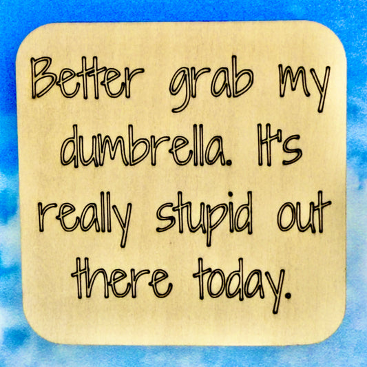 2.5" basewood square with “Better grab my dumbrella. It's really stupid out there today.“ laser engraved text.