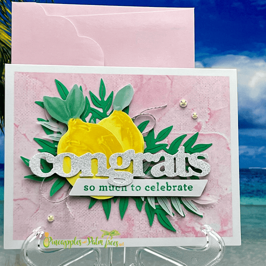 A cheerful handmade greeting card with a lemon theme. Background is pink, adding warmth to the scene. The card displays two fresh lemons, symbolizing positivity. A tag on the card reads "congratulations," adding a celebratory element. The overall aesthetic is bright and inviting, perfect for sending well wishes to someone special. The image exudes a sense of joy and happiness, making it ideal for occasions like birthdays or other celebrations.