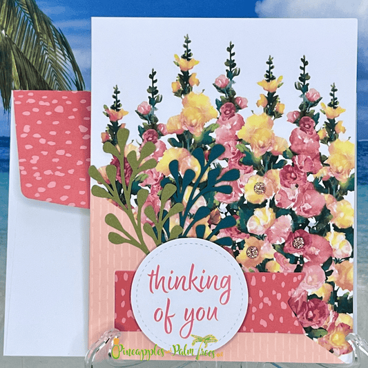 Greeting card “Thinking of You” with a bright floral snapdragon meadow illustration on the front cover.