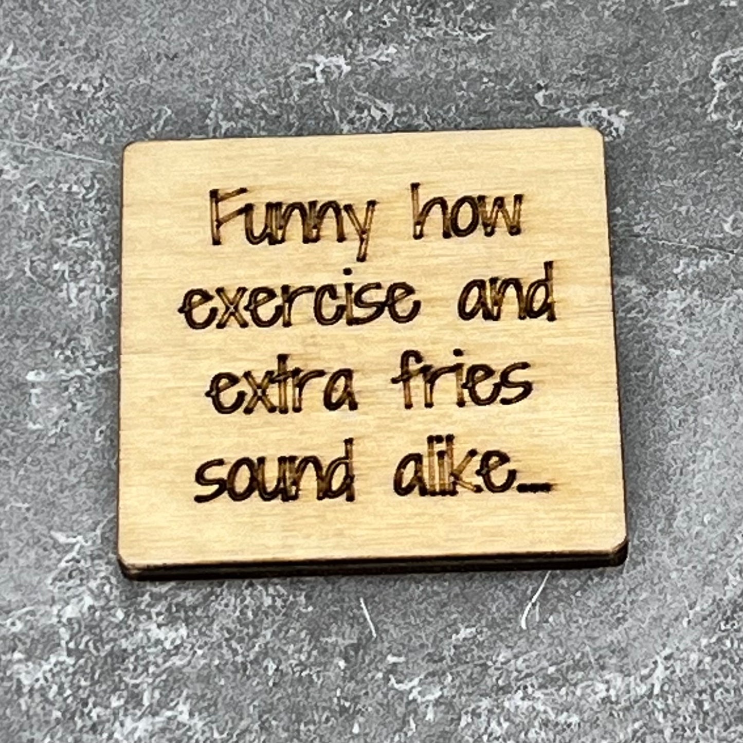 2" wood square with “Funny how exercise and extra fries sound alike…“ laser engraved