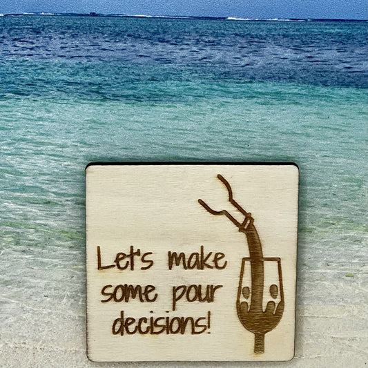 2”x2” wooden square with “ Let's Make Some Pour Decisions!“ and wine being poured into a wine glass, laser engraved. Background scene is a tropical ocean.