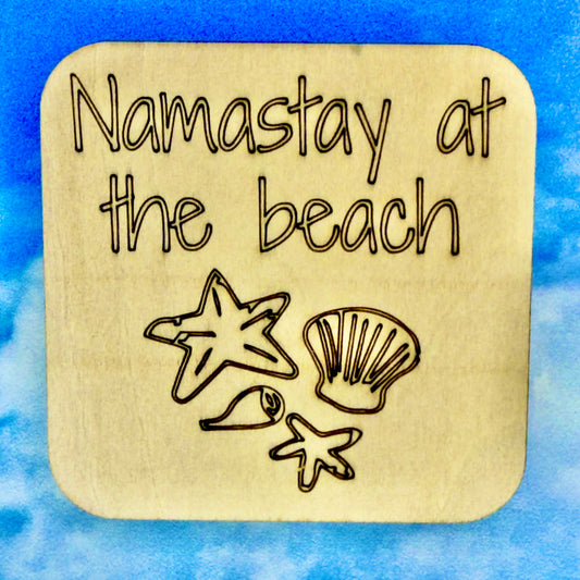 2.5" basewood square with “Namastay at the beach“ laser engraved text with image of sea shells.