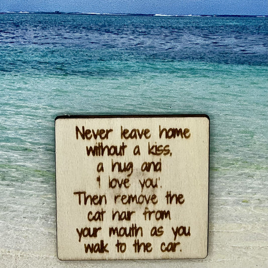 2”x2” wooden square with “Never Leave Home Without A Kiss, a hug and 'I Love You.' Then Remove the Cat Hair From Your Mouth As You Walk to the Car.“ laser engraved. Background scene is a tropical ocean.