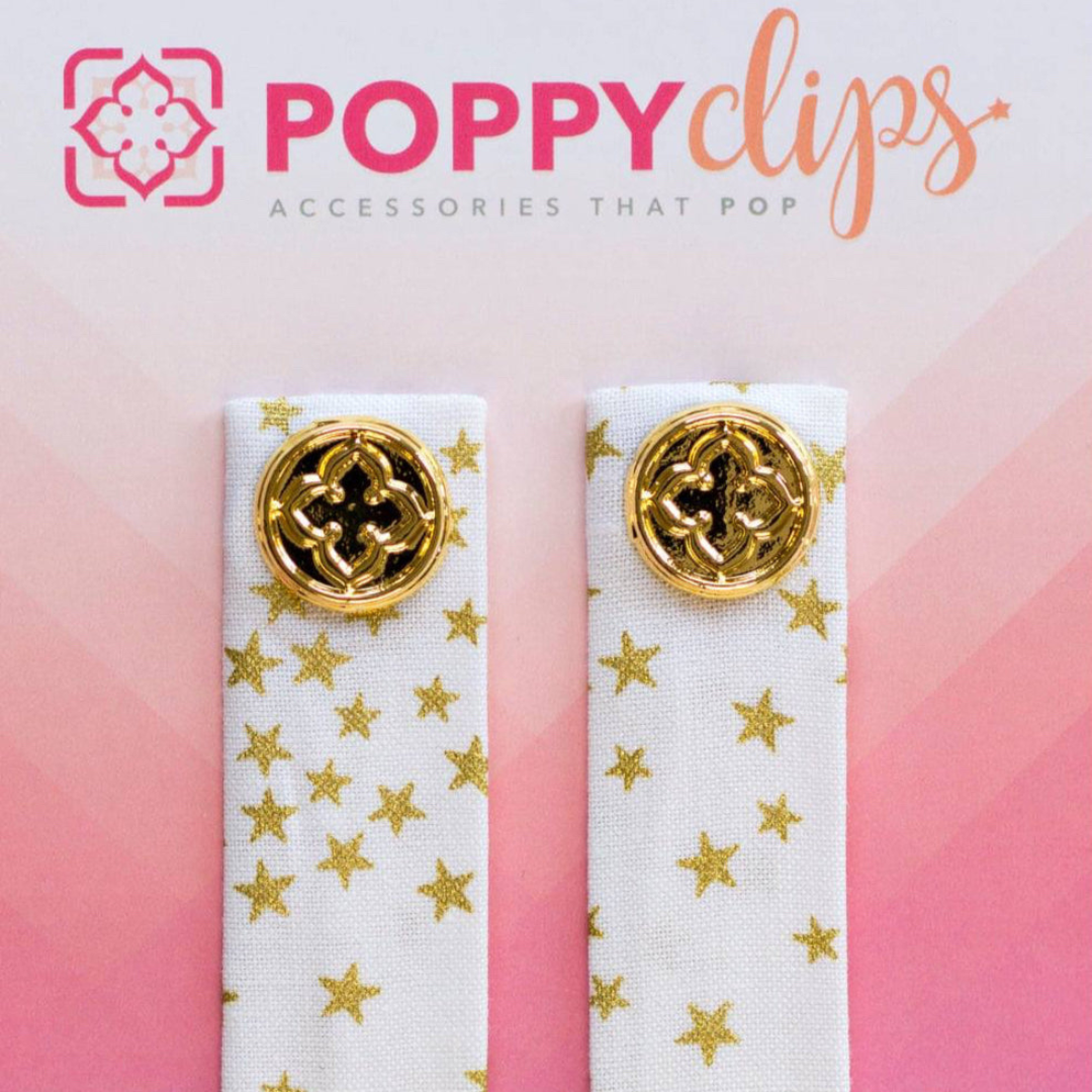 Two 5 ¼” long by 7/8” wide white material with tiny stars in a random pattern, and a magnet at each end.  The outer magnet is a decorative gold medallion with the company logo. 