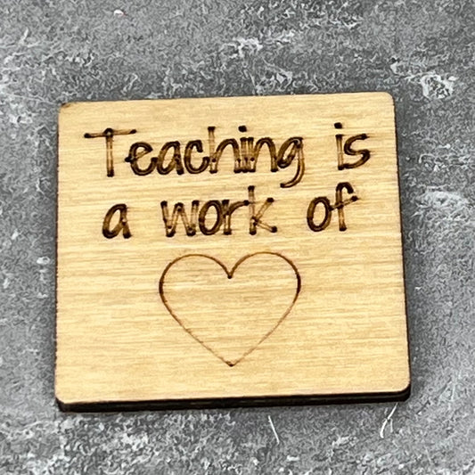 2" wood square with “Teaching is a work of {heart}    “ laser engraved