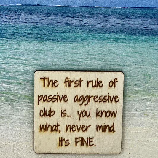 2”x2” wooden square with “The First Rule of Passive Aggressive Club is... You Know What, Never Mind. It's FINE.“ laser engraved. Background scene is a tropical ocean.