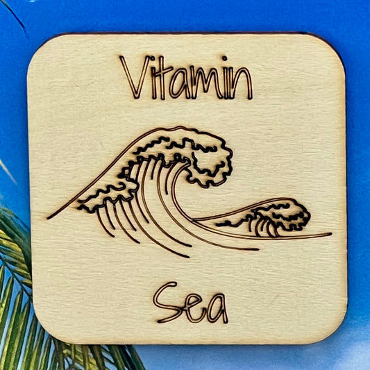 2.5" basewood square with “Vitamin Sea“ laser engraved text, along with an image of an ocean wave in the center.