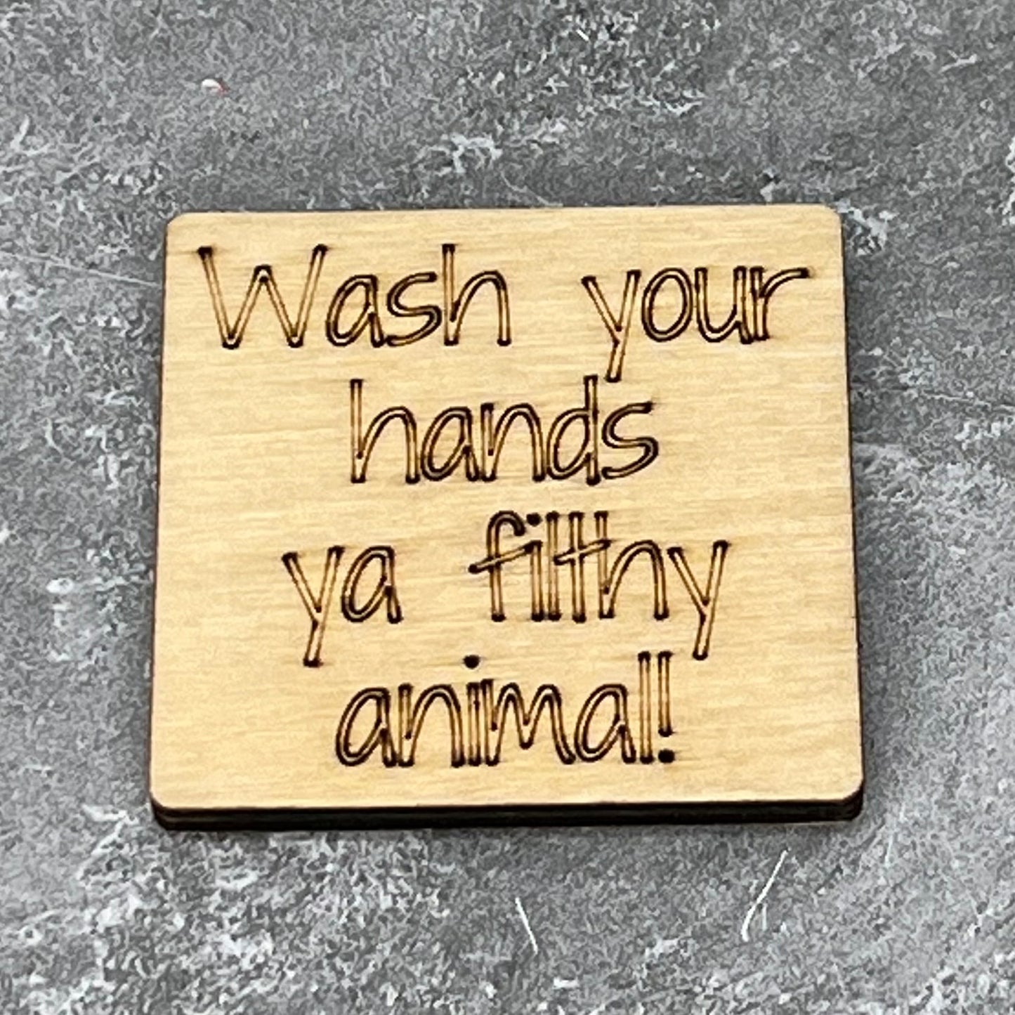 2.5" basewood square with “Wash your hands ya filthy animal“ laser engraved text.