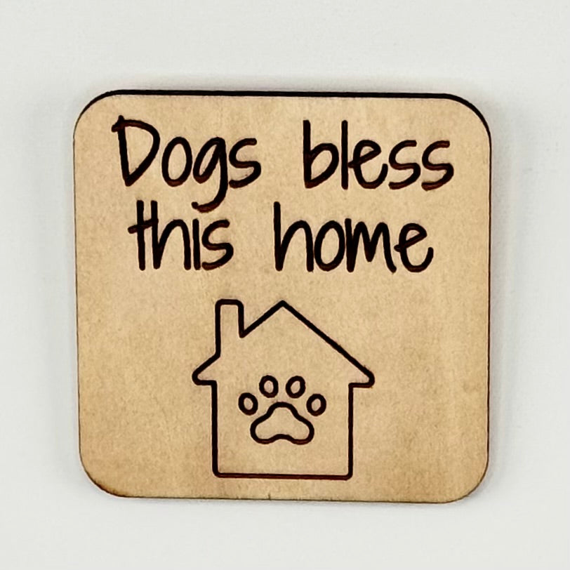 Laser-cut wooden fridge magnet engraved with the quote ‘Dogs Bless This Home’ with a dog-house icon — handcrafted décor gift for dog lovers.