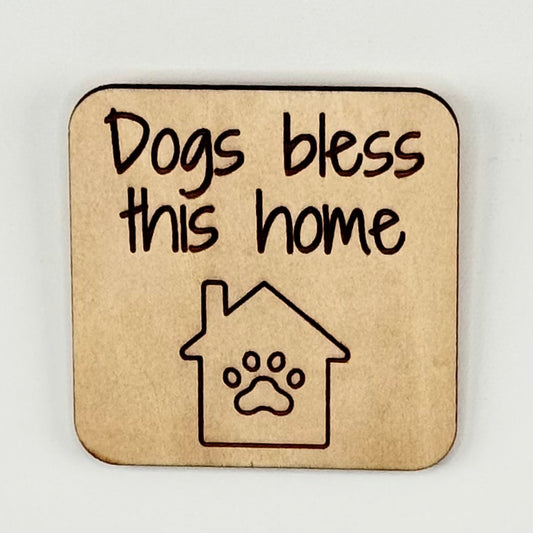 Laser-cut wooden fridge magnet engraved with the quote ‘Dogs Bless This Home’ with a dog-house icon — handcrafted décor gift for dog lovers.