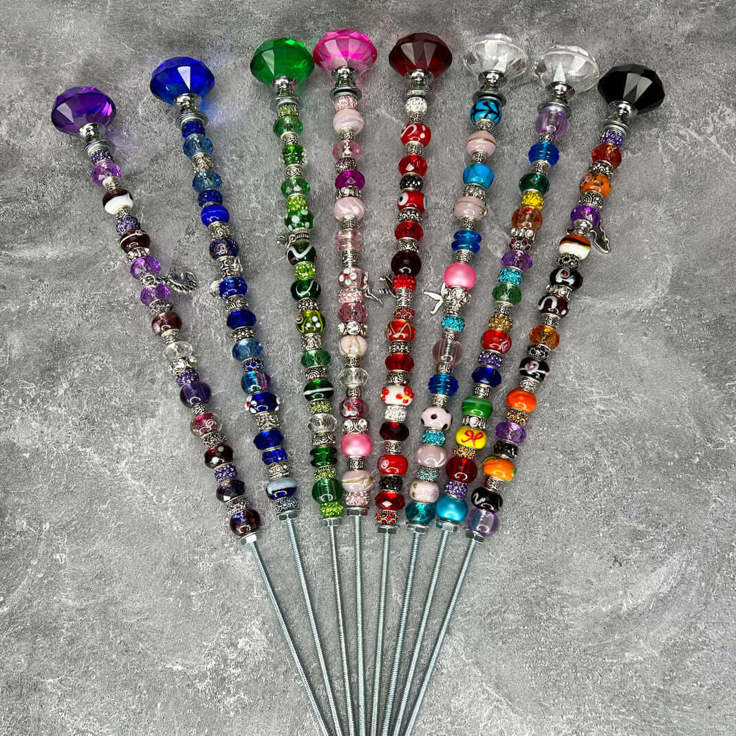 Set of 13-inch decorative garden stakes topped with large faceted crystals and adorned with colorful glass beads in purple, blue, green, pink, red, teal and orange — perfect for adding sparkle to garden beds or potted plants.