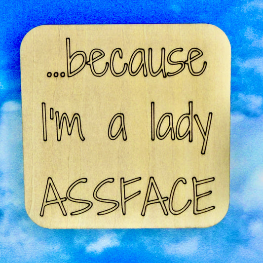 2.5" basewood square with “…because I'm a lady, ASSFACE“ laser engraved text.