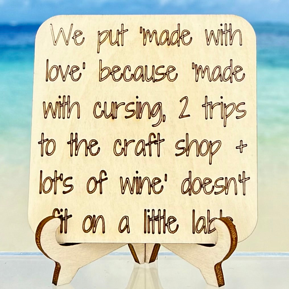 Funny fridge magnet: ‘We put made‑with‑love because made‑with‑cursing, 2 trips to the craft shop & lots of wine doesn’t fit on a little label’ — humorous quote decor.
