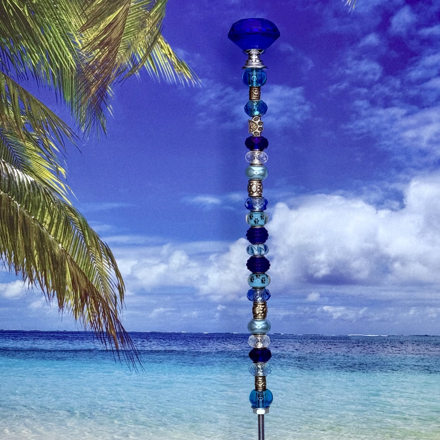 Aqua blue garden stake with paw print design — decorative metal yard décor for pet lovers.
