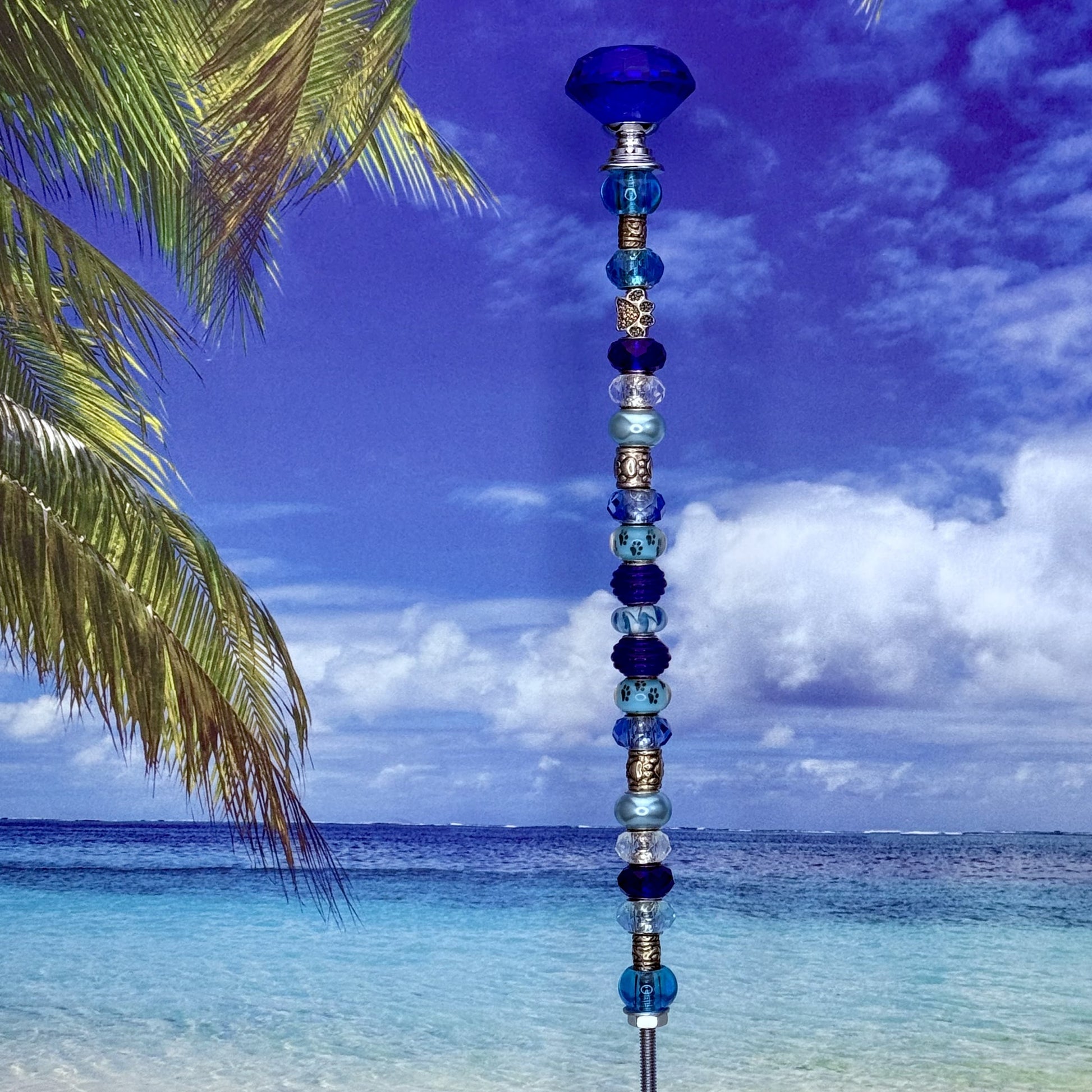 Aqua blue garden stake with paw print design — decorative metal yard décor for pet lovers.
