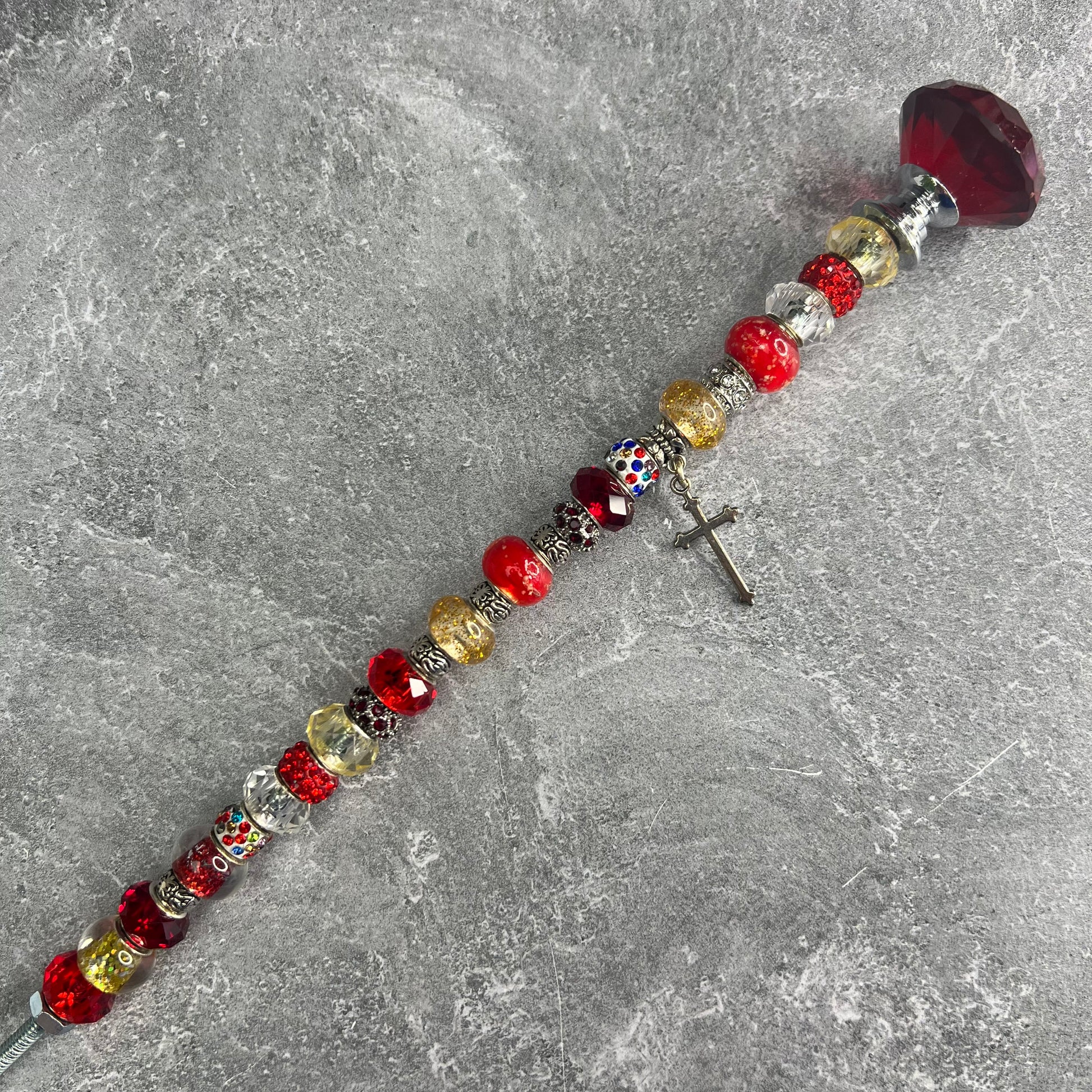 Crimson metal garden stake in the shape of a cross — inspirational Christian yard décor.

