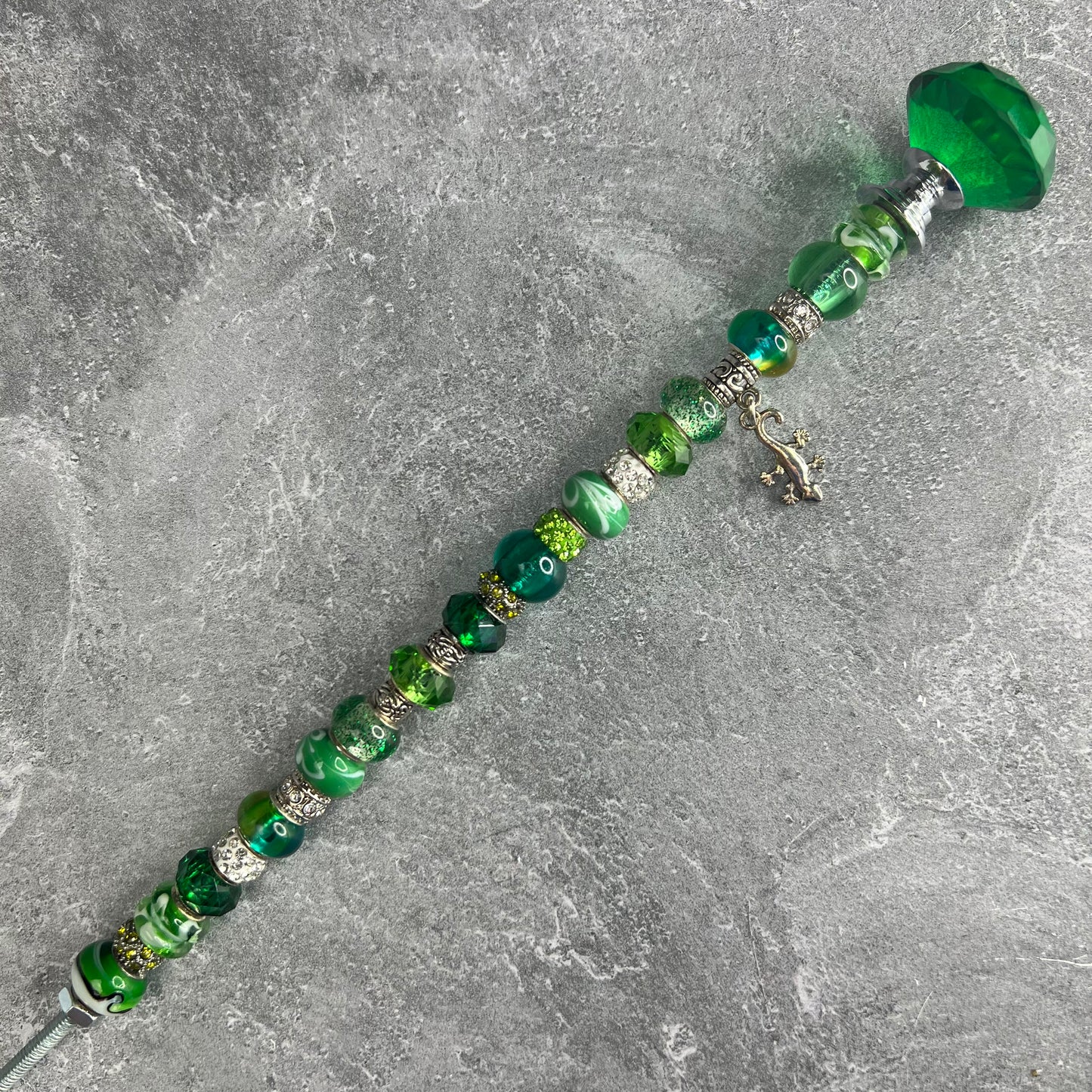 Green metal garden stake in the shape of a gecko — decorative outdoor yard décor.