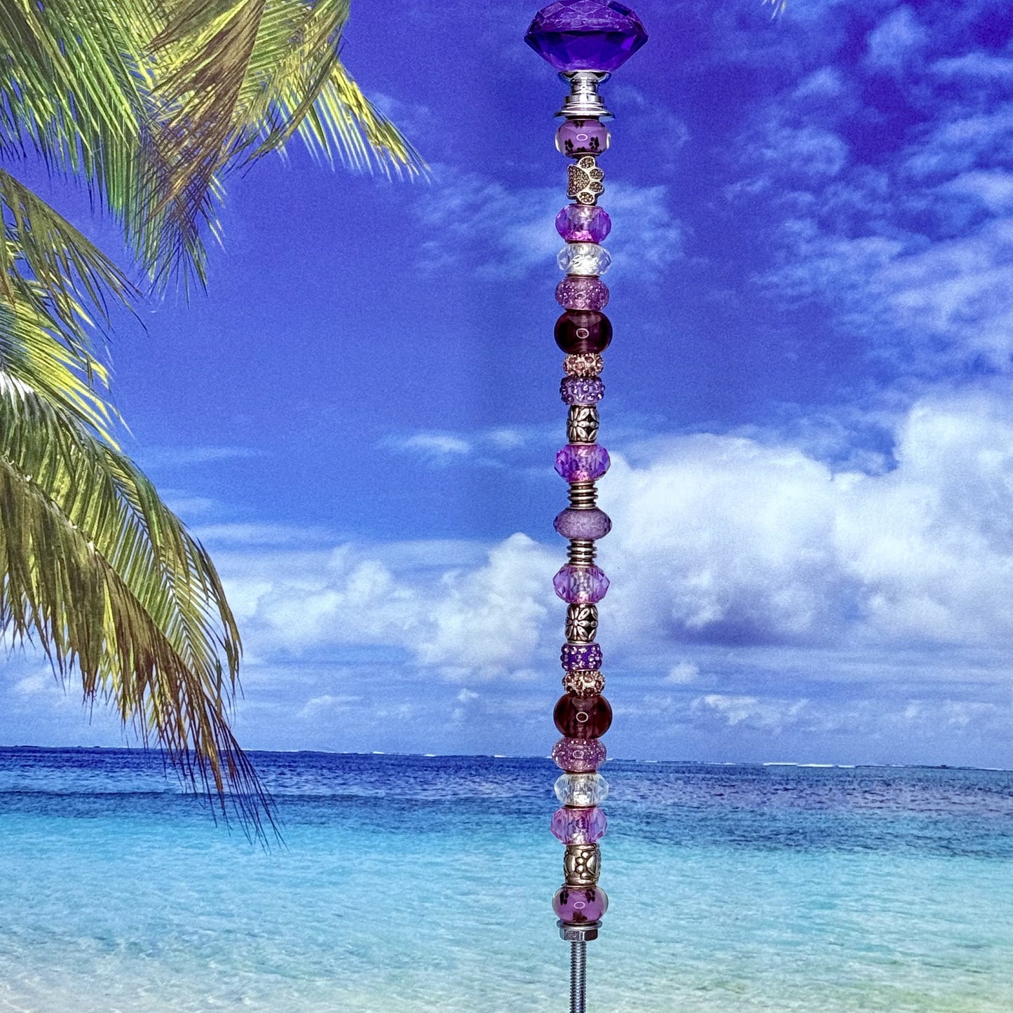 Purple metal garden stake with paw print and petal design — cute pet and floral-themed outdoor décor.
