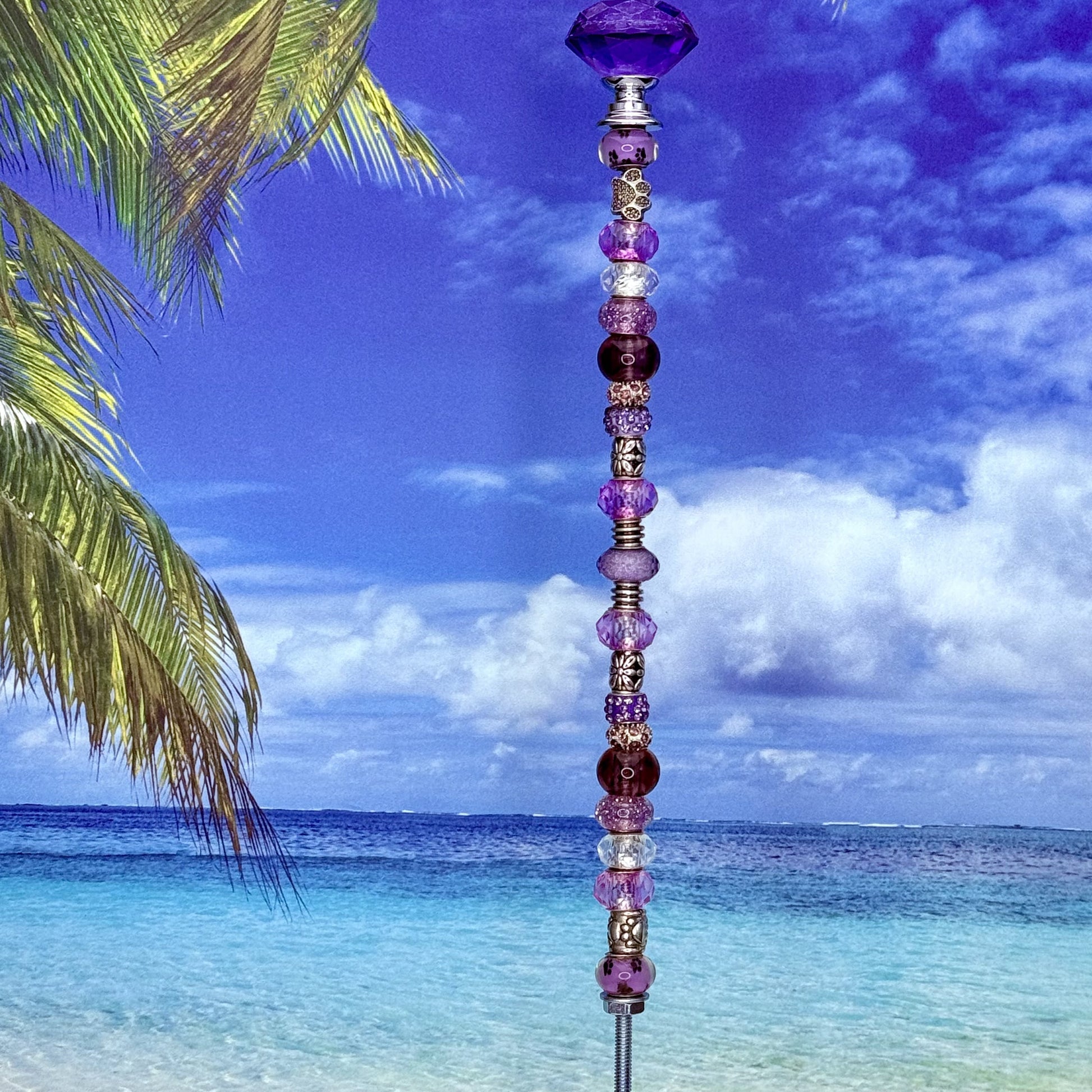 Purple metal garden stake with paw print and petal design — cute pet and floral-themed outdoor décor.
