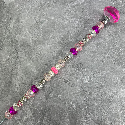 Pink metal garden stake with paw print and jeweled topper — cute outdoor decor for pet lovers.
