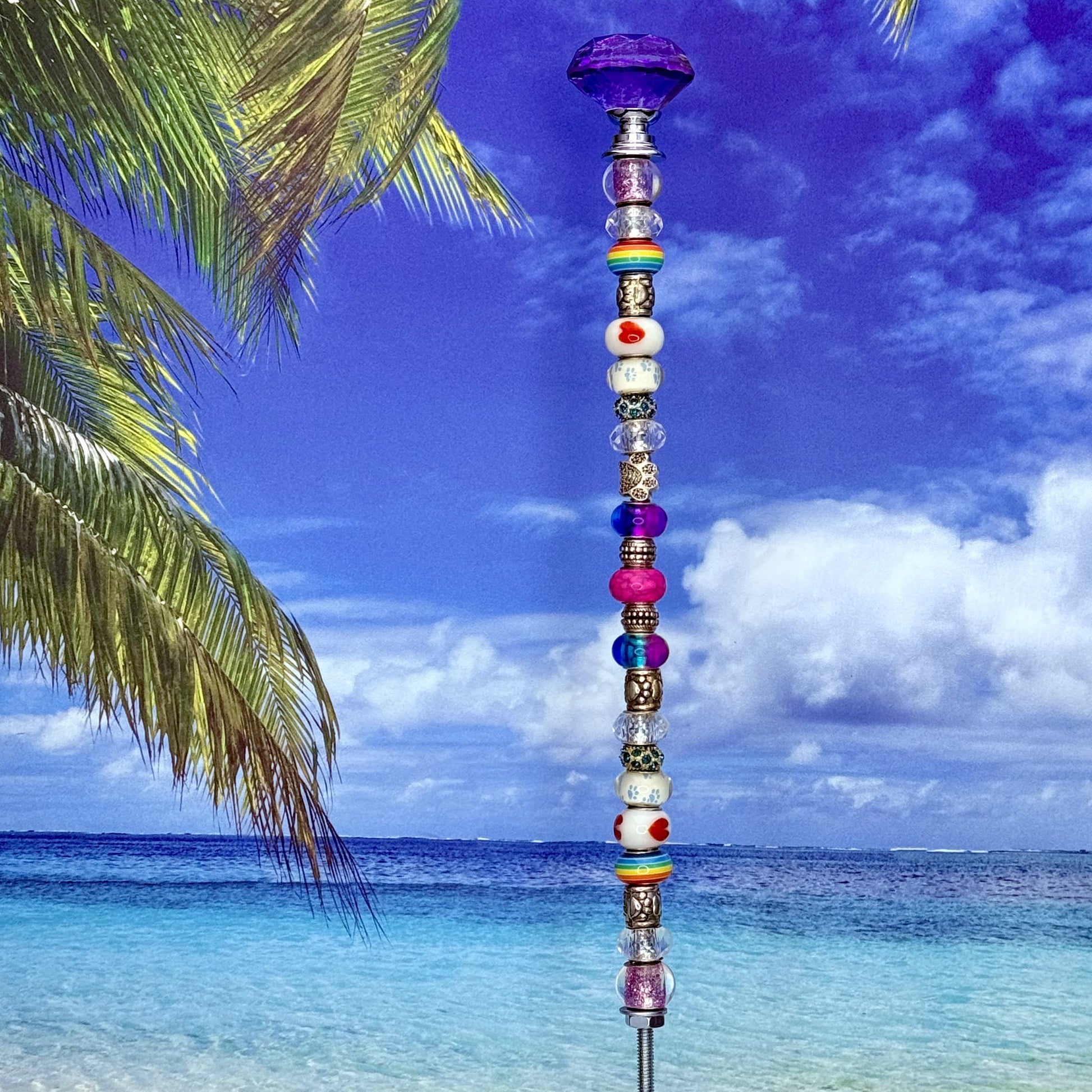 Colorful garden stake with rainbow paw prints and hearts — playful outdoor décor for pet lovers.
