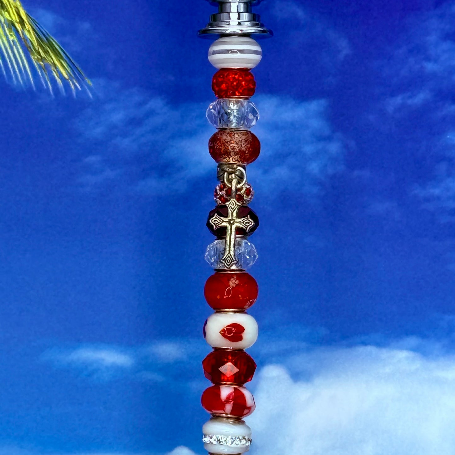 Red metal garden stake shaped like a heart-cross — decorative outdoor décor for faith‑inspired gardens.
