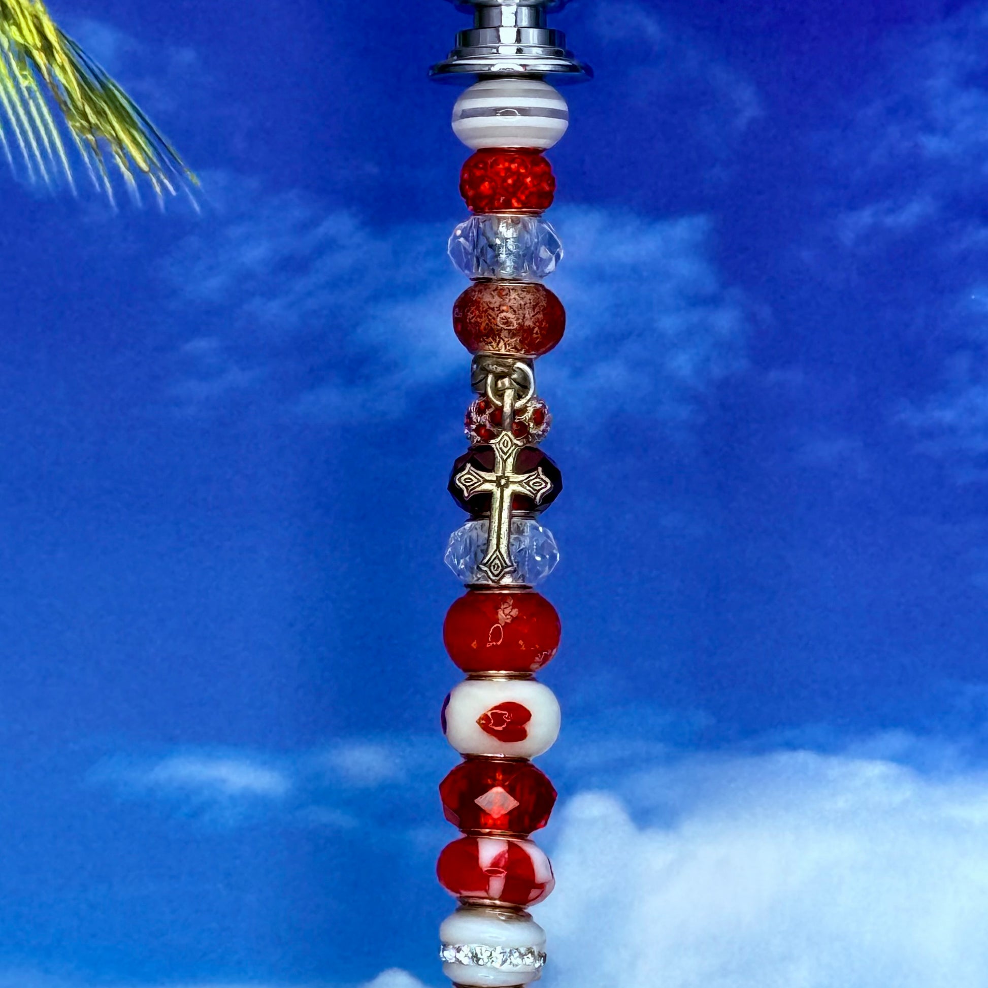 Red metal garden stake shaped like a heart-cross — decorative outdoor décor for faith‑inspired gardens.
