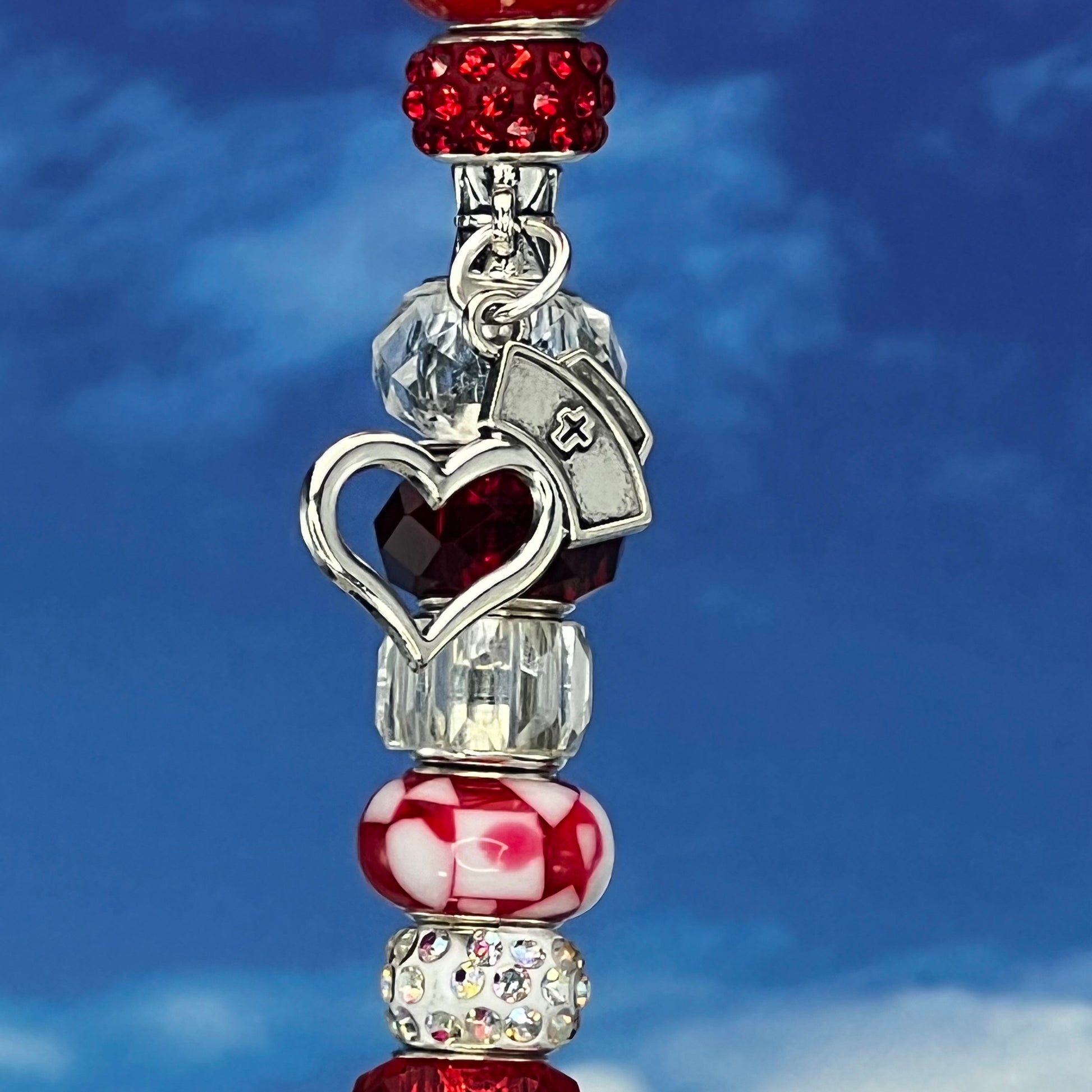 Red metal garden stake with a nurse’s heart cross design — ‘Scarlet Heart Healer’ faith and healing inspired yard décor.

