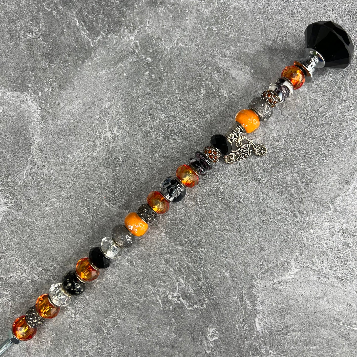 Black and orange metal garden stake featuring a motorcycle design — ‘Sunset Chopper Charm’ outdoor décor.
