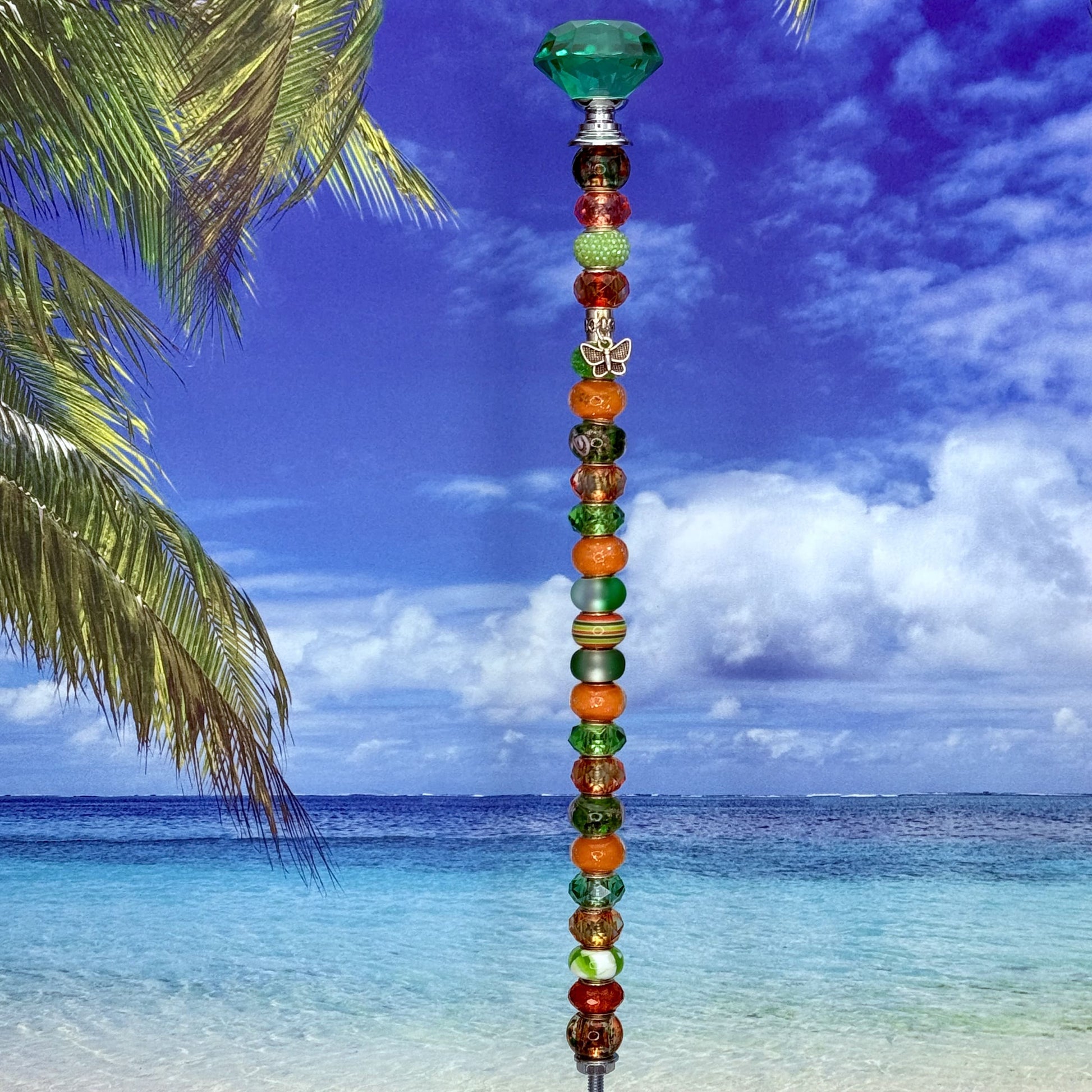 Green and orange metal garden stake with butterfly design — ‘Sunset Meadow’ outdoor decor.
