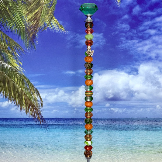 Green and orange metal garden stake with butterfly design — ‘Sunset Meadow’ outdoor decor.
