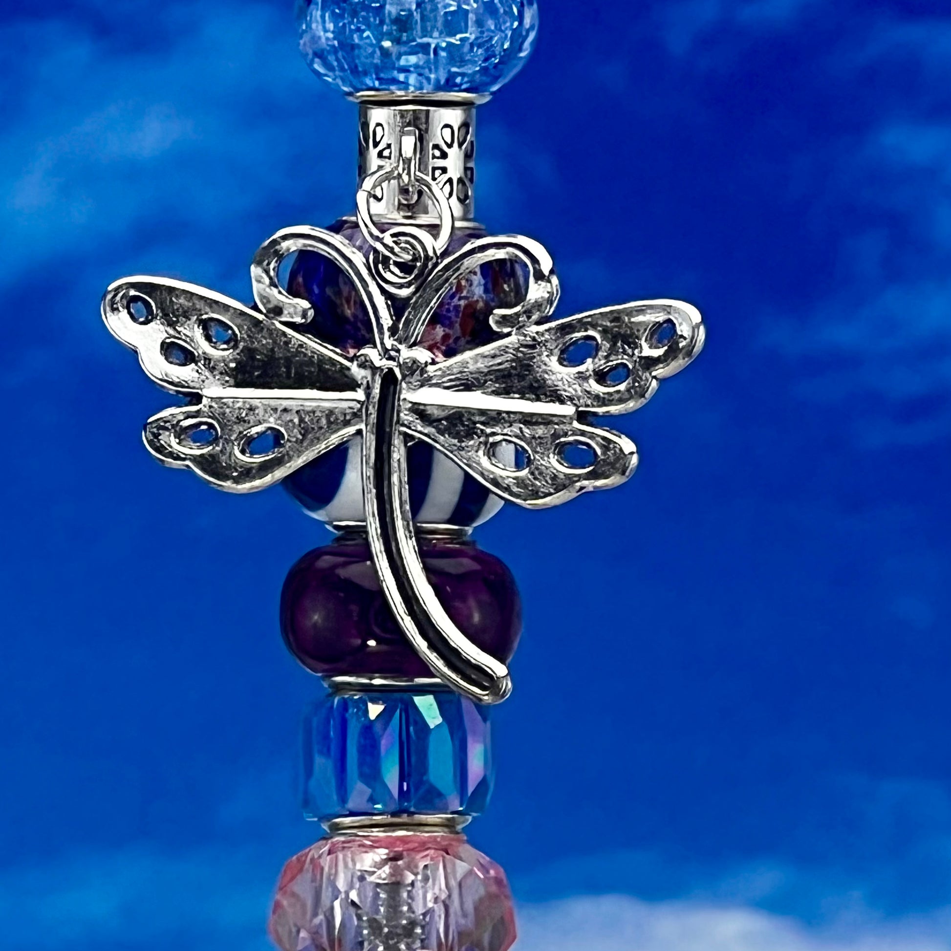 Metal garden stake featuring a dragonfly and tri‑tone blossom breeze in pink, blue, and purple — whimsical outdoor décor.