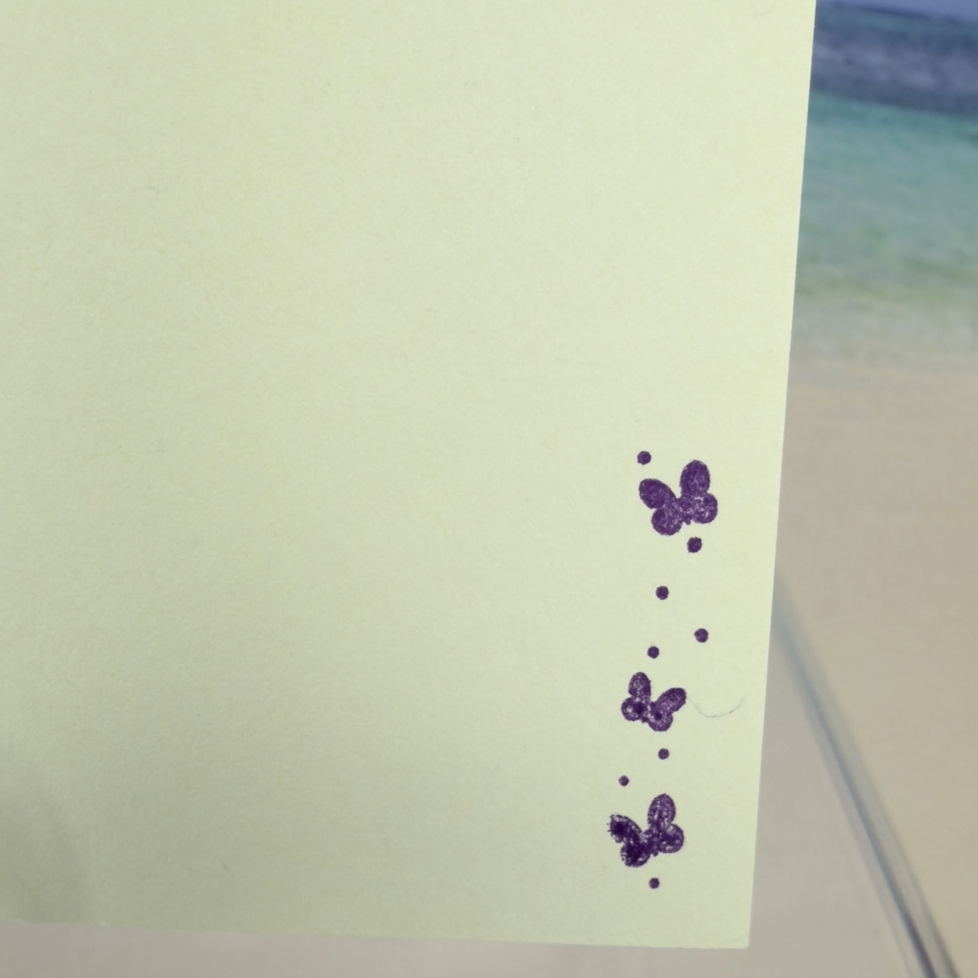 Details of a hand-crafted greeting card in green and lavender hues with the message ‘Happy Mother’s Day,’ shown with its matching envelope — elegant and loving floral design.