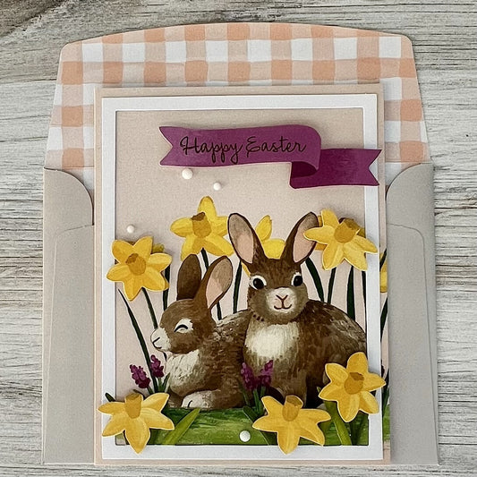 Happy Easter greeting card with two fluffy bunnies nestled in a floral design, from Pineapples and Palm Trees
