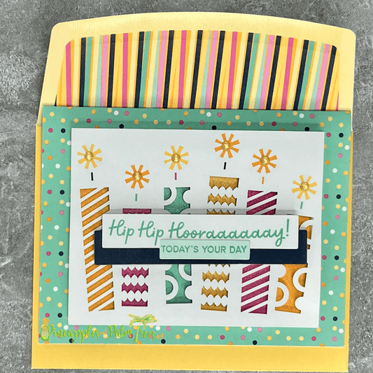 Greeting card with the message ‘Hip Hip Hooray — Today’s Your Day’ surrounded by birthday cake candles, shown with its matching envelope — celebratory and handcrafted for birthdays.