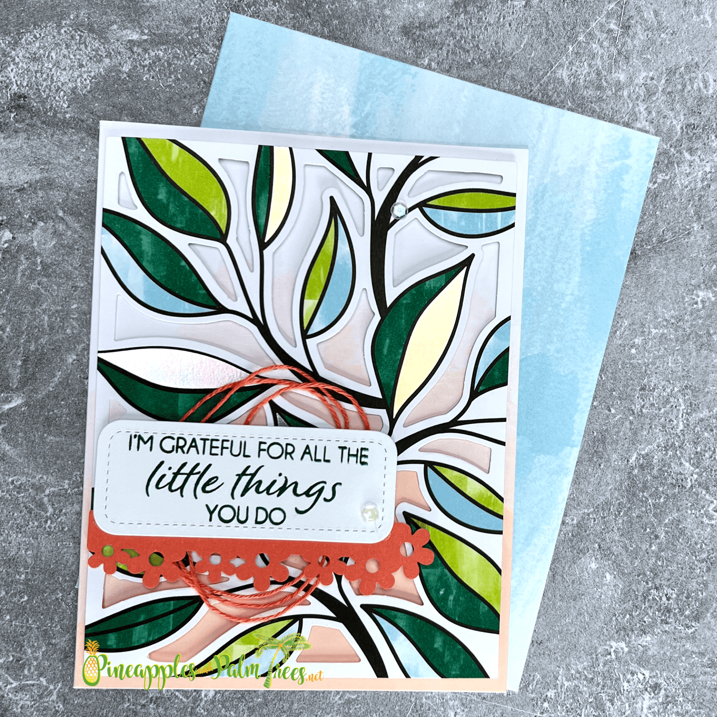 Greeting card with the message ‘I'm grateful for all the little things you do’ adorned with delicate leaf illustrations and shown with its matching envelope.