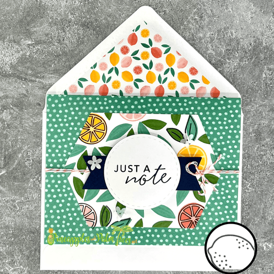 Greeting card reading ‘Just a Note’ with bright citrus fruit illustrations, shown with its matching envelope — cheerful and handcrafted.