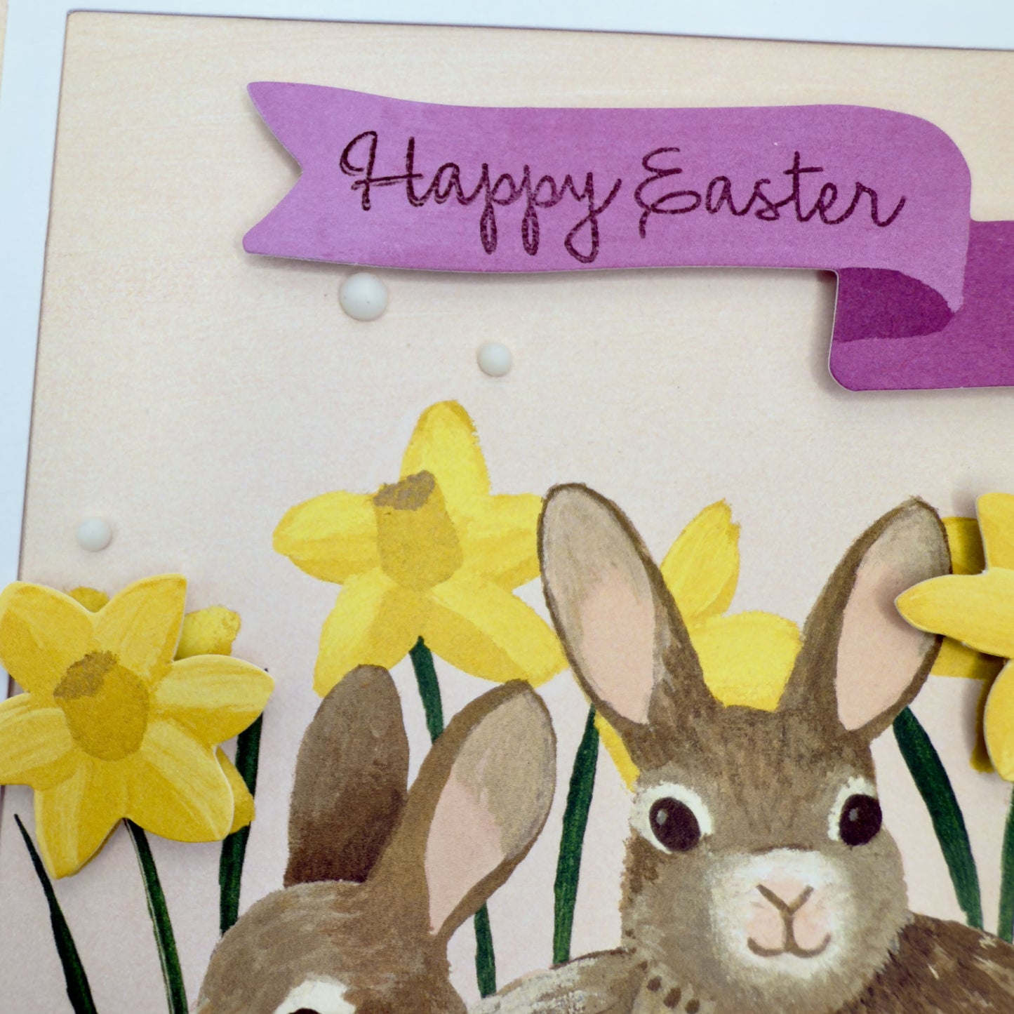 Happy Easter greeting card with two fluffy bunnies nestled in a floral design, from Pineapples and Palm Trees