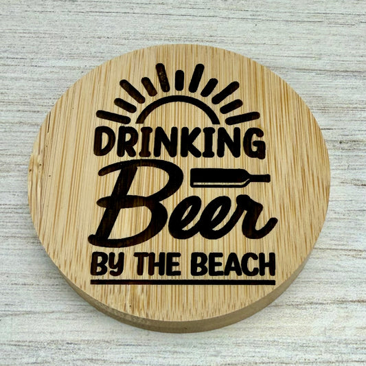 Round laser‑engraved bottle opener with “Drinking Beer by the Beach” design, perfect for summer or beach use.