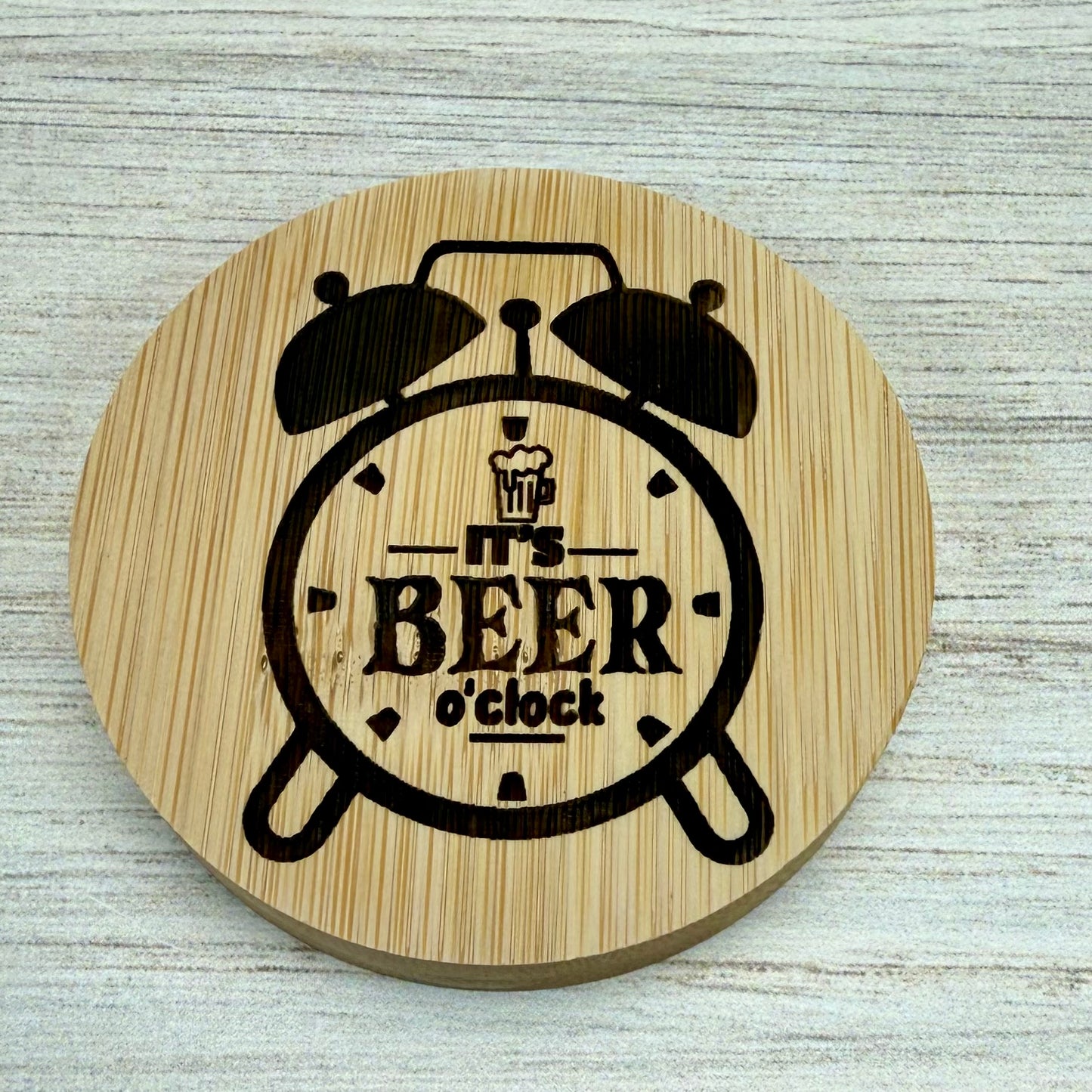 Round laser‑engraved bottle opener with “It’s Beer O’Clock” design, perfect for beer lovers and parties.