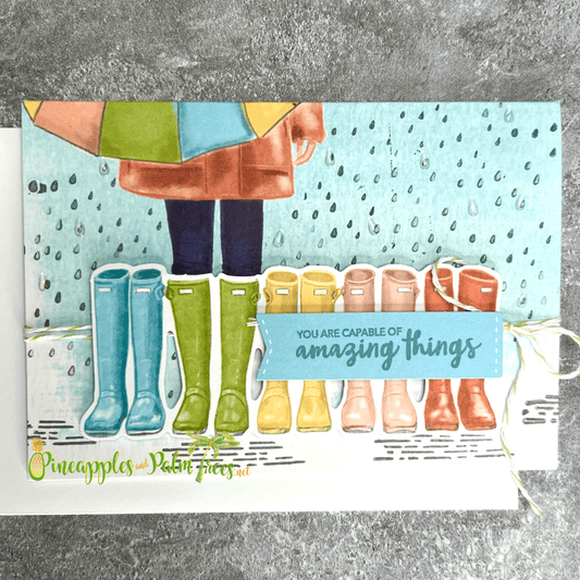 Encouraging greeting card with rain boots illustration and the message “You Are Capable of Amazing Things” on the front.