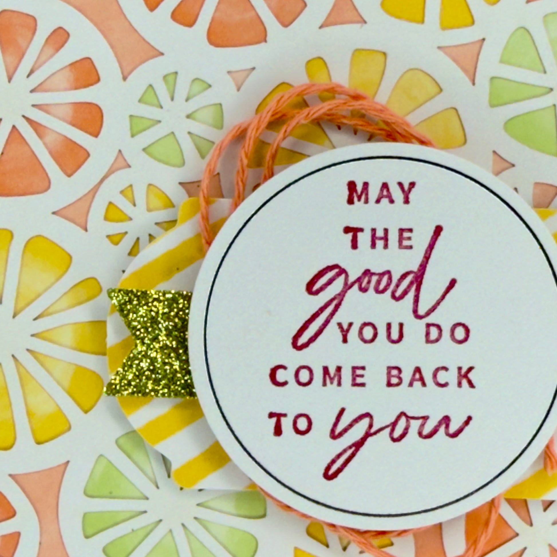 Close-up of handcrafted citrus details on greeting card with the text “May the good you do come back to you.”